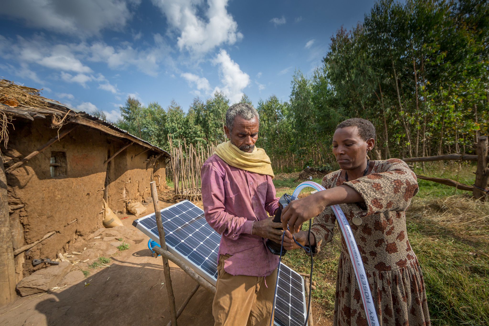 Sewagegn, a local smallholder farmer, and Gebeyaw, a data collector, set up Sewagegn's solar powered pump to irrigate her backyard garden in Danghesta, Amhara region of Ethiopia. Photo by Mulugeta AyeneWLE.