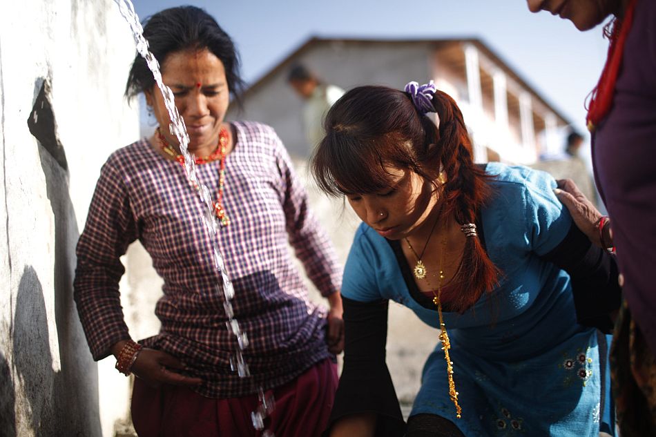 Women use a public tap in the center of Dhap. Before water management started in Dhap village, there used to be long lines of people waiting their turn to collect or use the water tap. Photo: Tom van Cakenberghe / IWMI