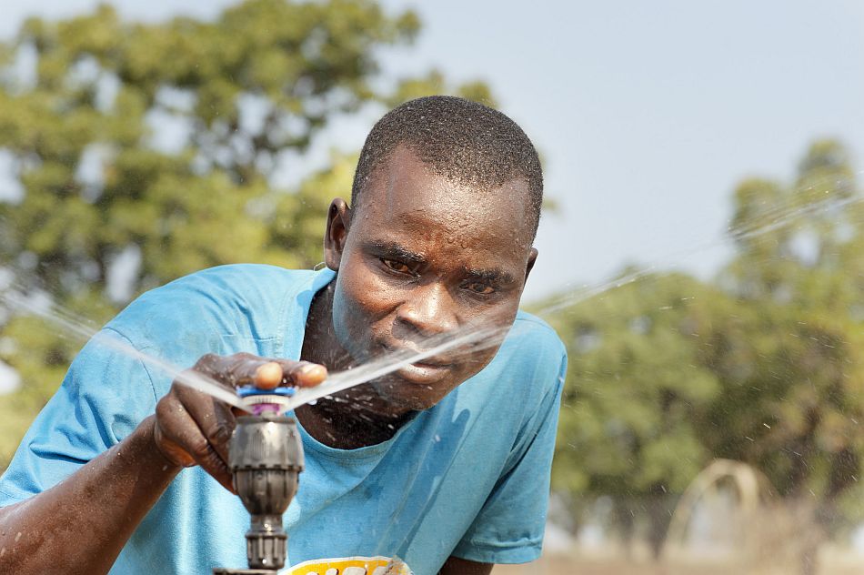 A farmer inspecting his sprinklers. Photo: Hamish John Appleby / IWMI